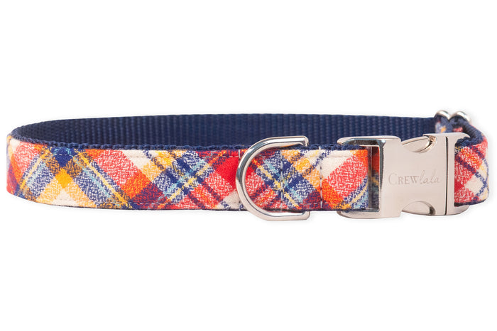 Adjustable dog collar with a colorful plaid pattern, layered over a nylon webbing base. Includes polished hardware: a buckle engraved with the brand name “Crewlala” and a secure D-ring positioned beside it.