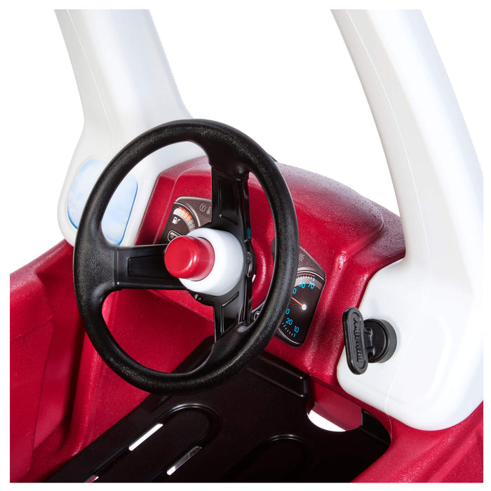 Black steering wheel with red horn, black key on the right, white pillar.
