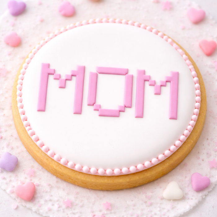 A round sugar cookie decorated with our Cross Stitch Mom Cookie Stencil in pink royal icing, BakeArt Stencils, AI generated