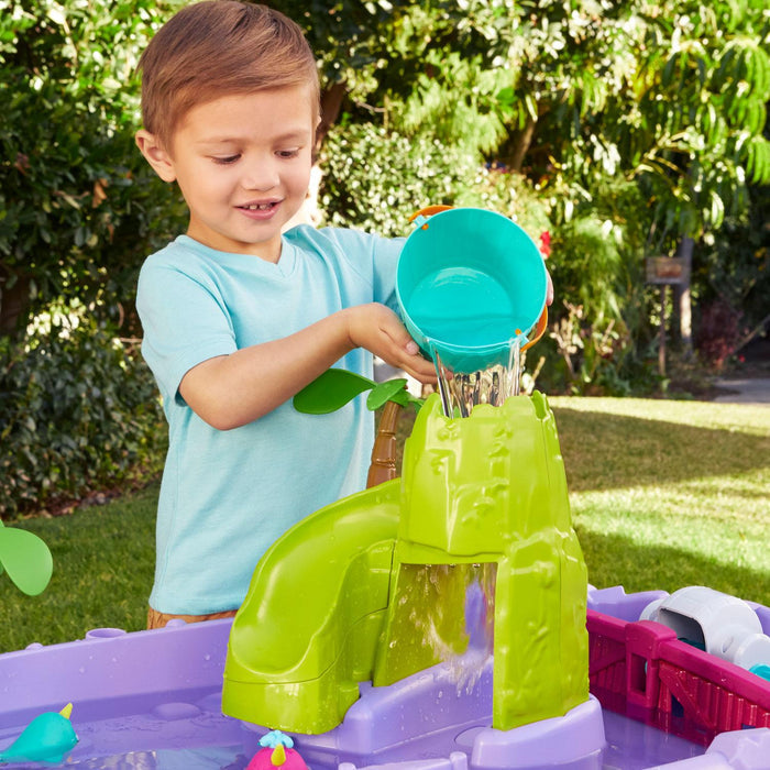 Boy pouring water with the bucket to create a waterfall
